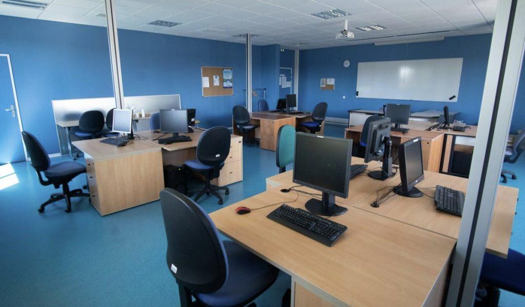 Une salle de formation avec des postes informatiques