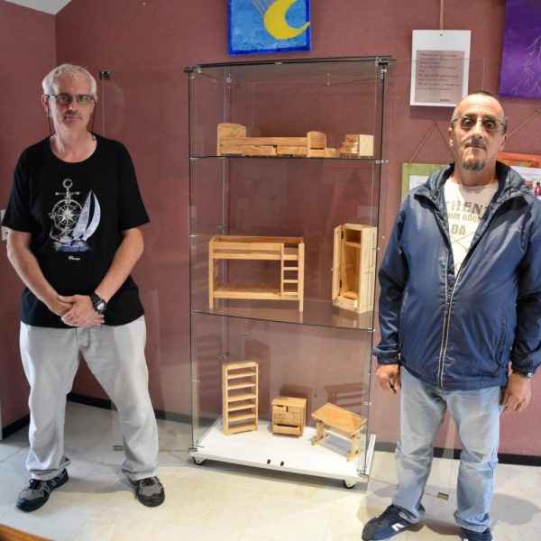 Les ouvriers de la menuiserie du Hameau devant les meubles miniatures