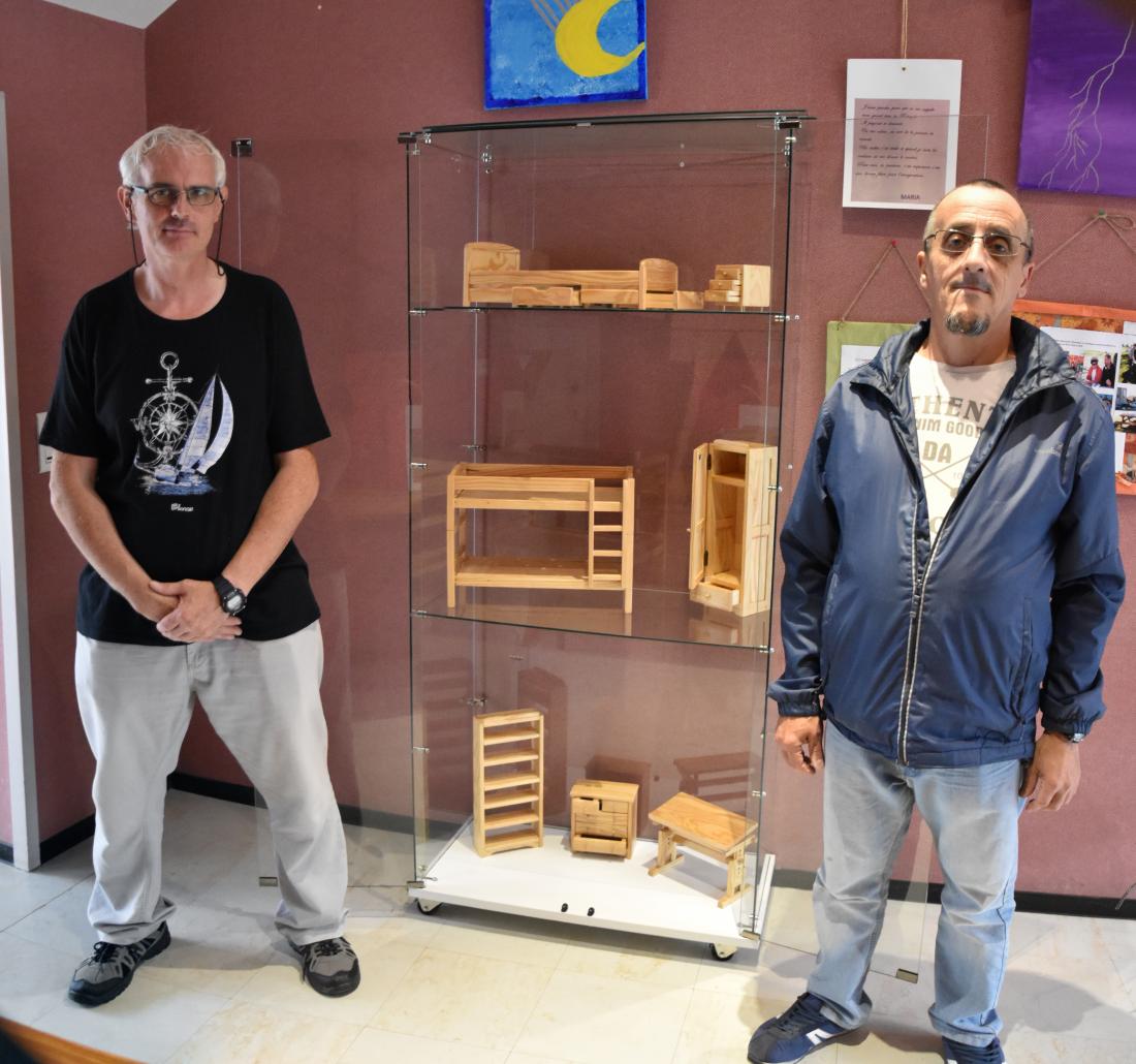 Les ouvriers de la menuiserie du Hameau devant les meubles miniatures