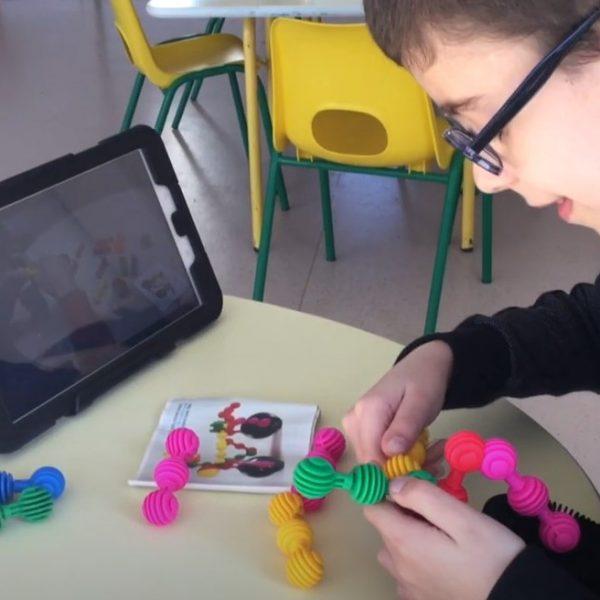 Un enfant assemble des pièces avec l'aide d'une tablette numérique