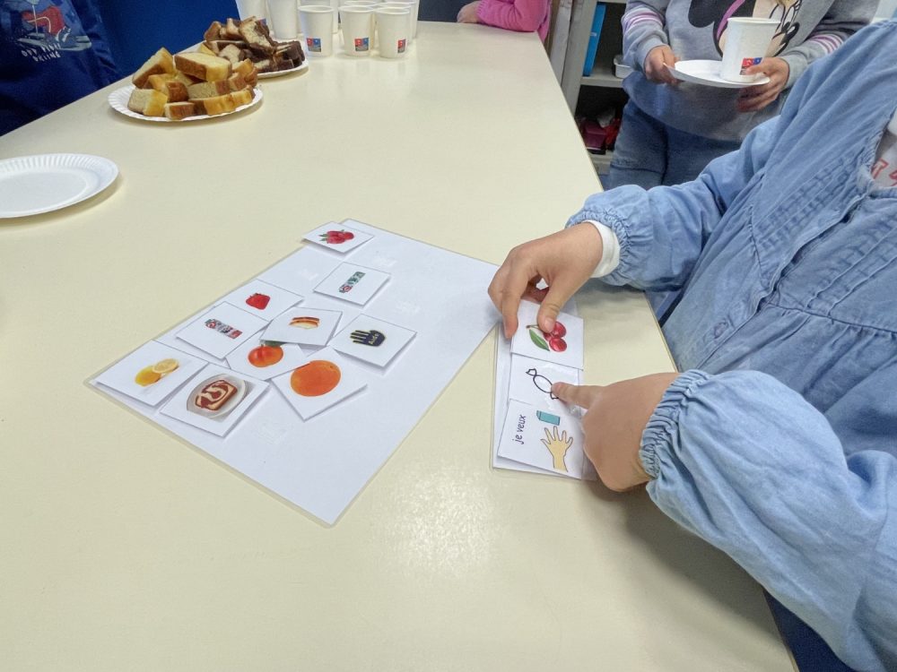 Un enfant demande du gouter à l'aide de pictogrammes.