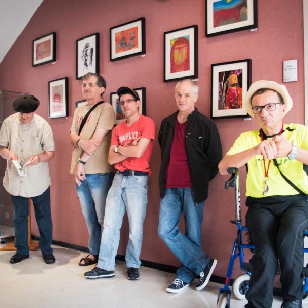 Les artistes du Foyer de Vie d'Espiute posent devant leurs œuvres au siège de l'Adapei.