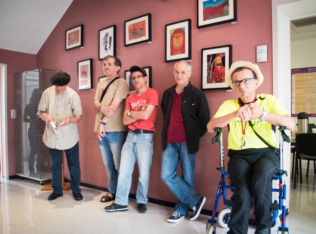 Les artistes du Foyer de Vie d'Espiute posent devant leurs œuvres au siège de l'Adapei.