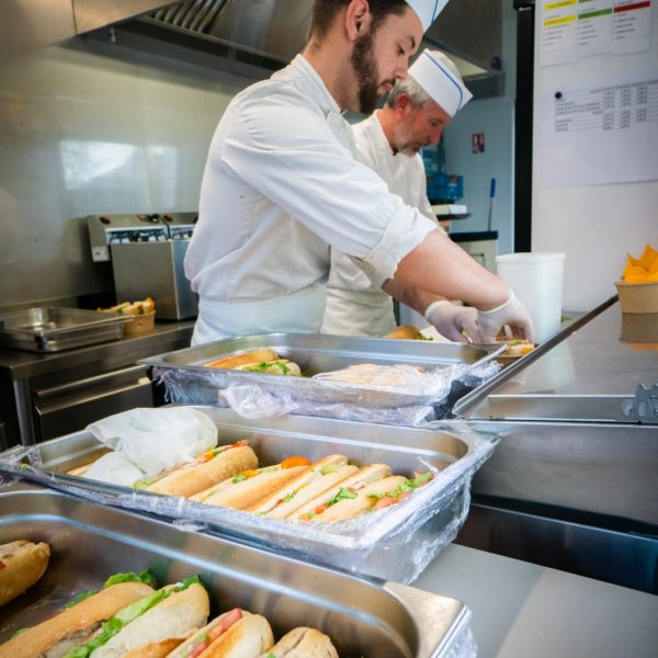 Deux ouvriers préparent les sandwiches au Cabanon du Hameau