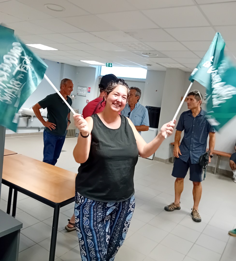 Une accompagnatrice d'Atades brandit les drapeaux de la Section au stade du Hameau